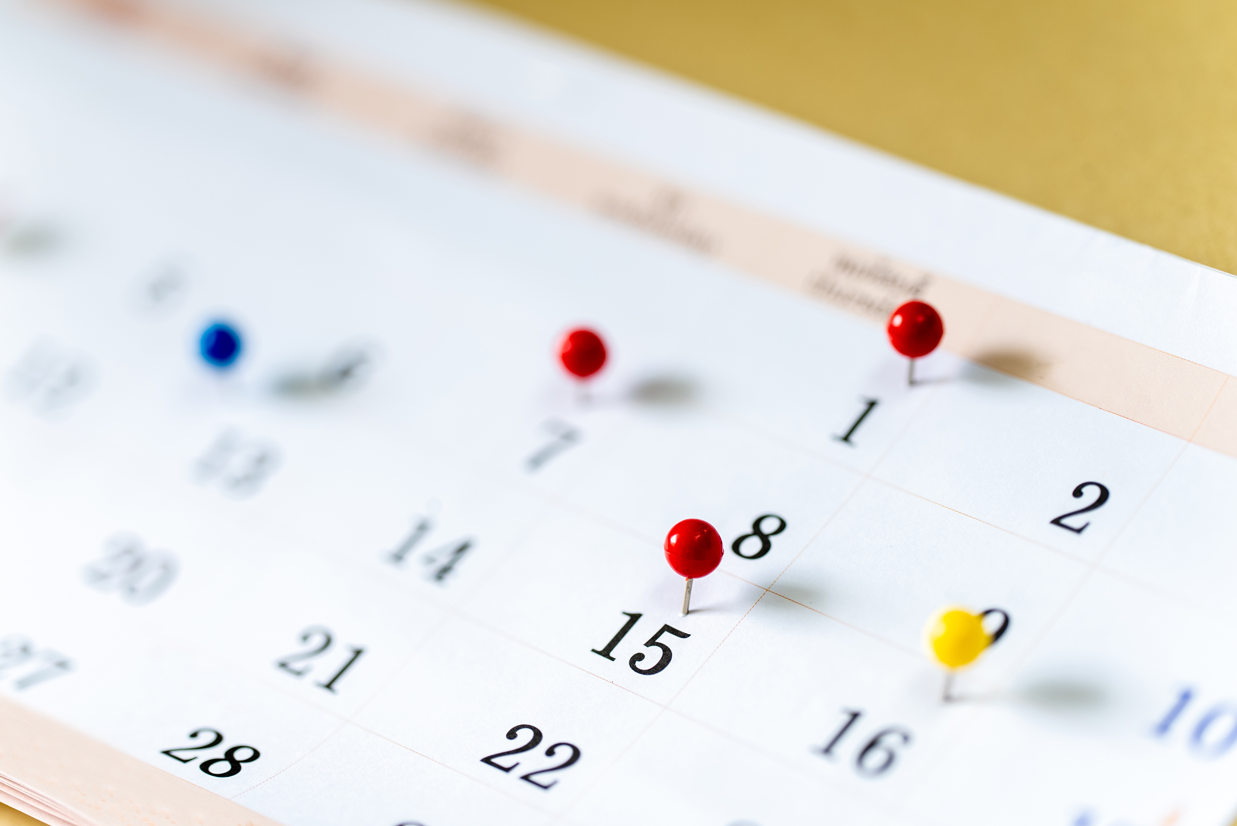 Closeup Colorful drawing pins on Calendar page with date