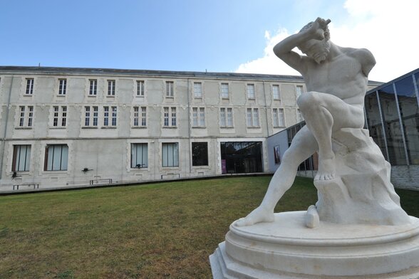 Statue de marbre blanc sur la pelouse, devant la façade du musée Bernard d’Agesci