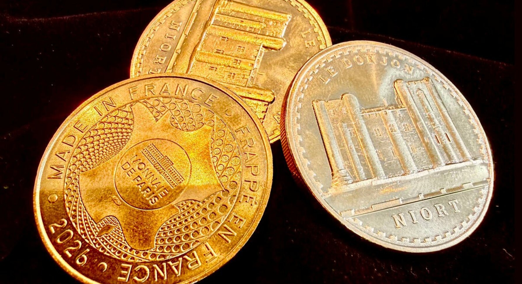 Avers et revers de trois médailles : gravure du monument inscrite « Le Donjon – Niort » et poinçon Monnaie de Paris millésimé 2026